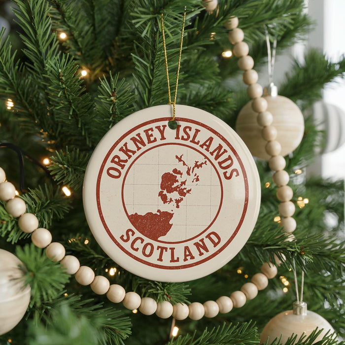 A Christmas tree decorated with ornaments, including a circular ornament with the text "ORKNEY ISLANDS SCOTLAND" and a map of the Orkney Islands.