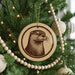 A Christmas tree decorated with ornaments, including a circular ornament featuring a close-up of an otter's face.