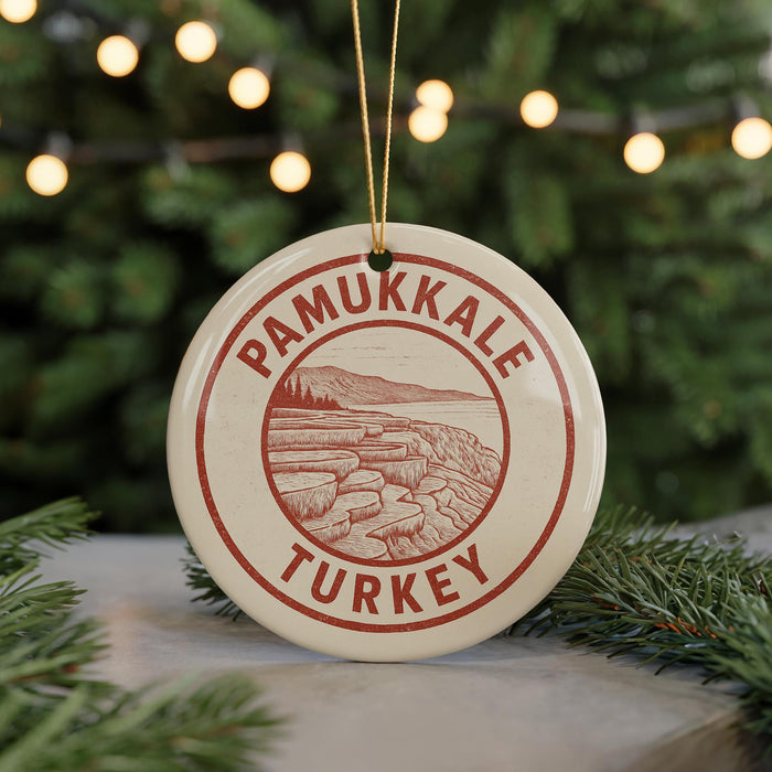 A circular ornament with the text "PAMUKKALE TURKEY" printed on it, hanging from a string.