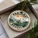 A circular ornament with the text "PANTANAL BRASIL" and an illustration of a bird standing in a tropical landscape.