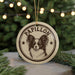 A circular ornament featuring a Papillon dog's face, with the word "Papillon" written around the edge.