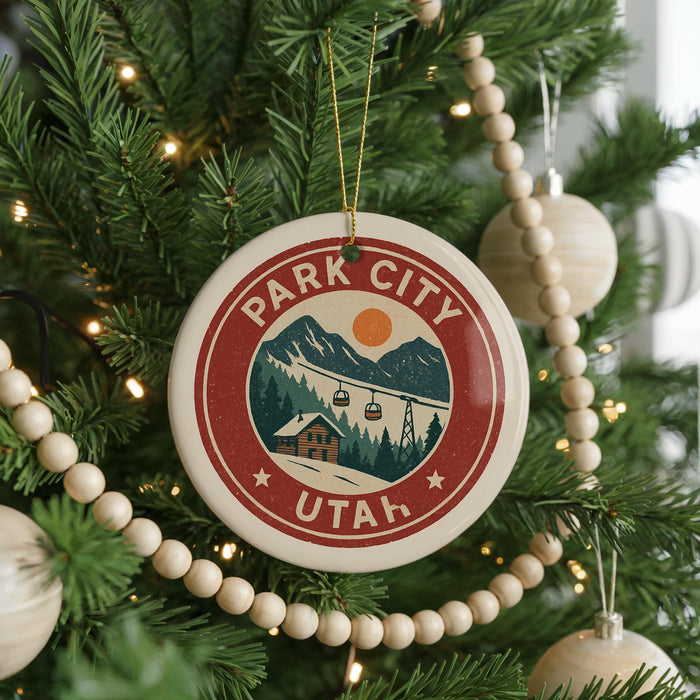 A circular ornament on a Christmas tree, featuring a mountain landscape and ski lifts, with the text "PARK CITY UTAH" prominently displayed.