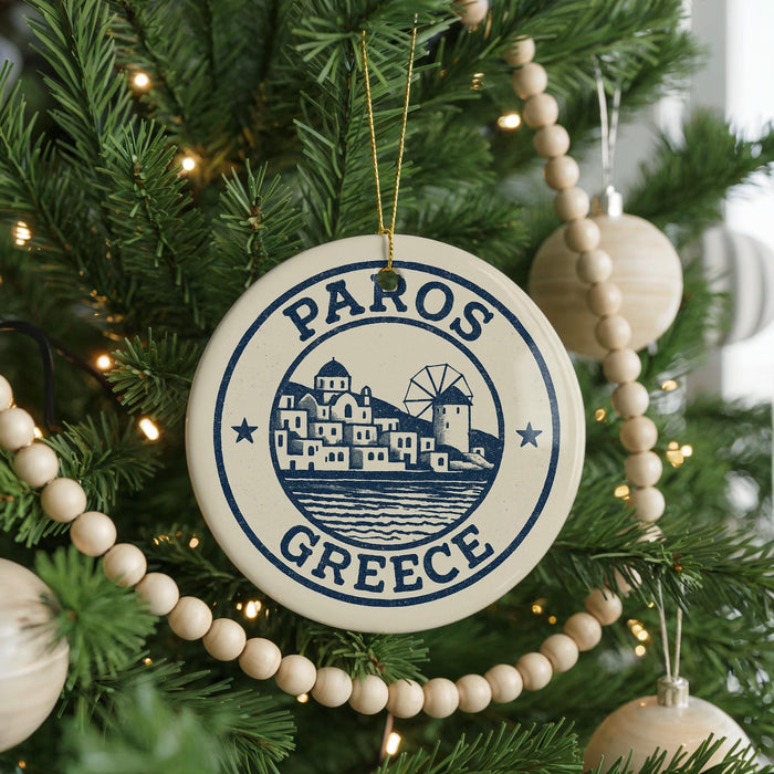 A circular ornament on a Christmas tree, featuring a design of a Greek island and the text "PAROS GRECE".