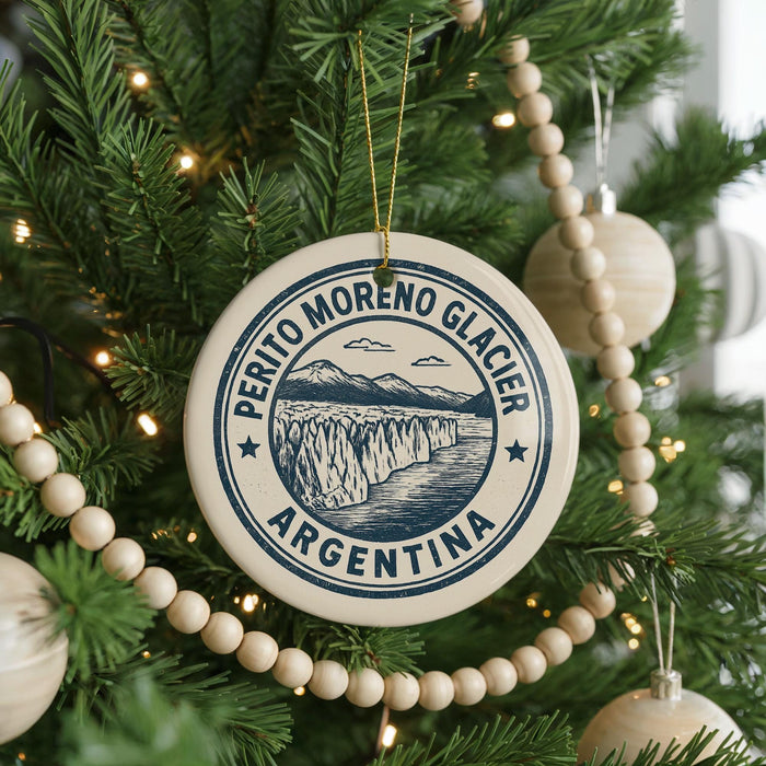 A Christmas tree decorated with ornaments, including a circular ornament with a graphic of a mountain and the text "PERITO MORENO GLACIER ARGENTINA".