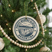 A Christmas tree decorated with ornaments, including a circular ornament with a graphic of a mountain and the text "PERITO MORENO GLACIER ARGENTINA".