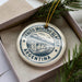 A circular ornament with the text "PERITO MORENO GLACIER ARGENTINA" printed on it, surrounded by pine branches.