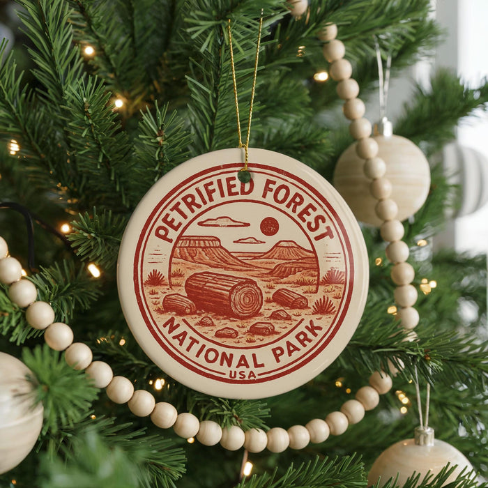 A Christmas tree decorated with ornaments, including a circular ornament with a red and white design that says "PetriFied Forest National Park USA".