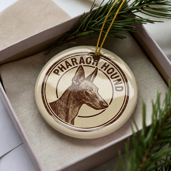 A circular ornament with a brown and white design featuring a dog's head and the text "PHARAHOUND" is displayed in a box.
