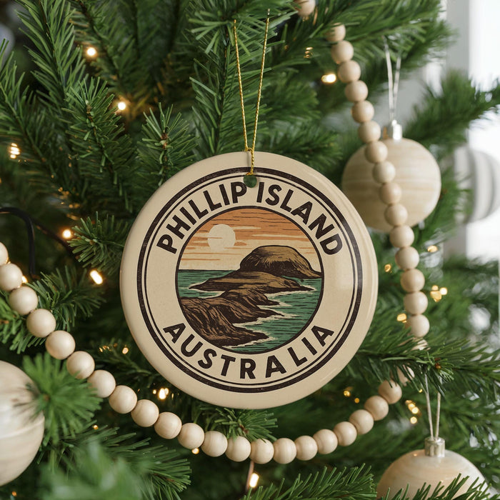A Christmas tree decorated with ornaments, including a circular ornament with the text "PHILLIP ISLAND AUSTRALIA" and a scenic illustration of a coastline.