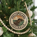 A Christmas tree decorated with ornaments, including a circular ornament with the text "PHILLIP ISLAND AUSTRALIA" and a scenic illustration of a coastline.