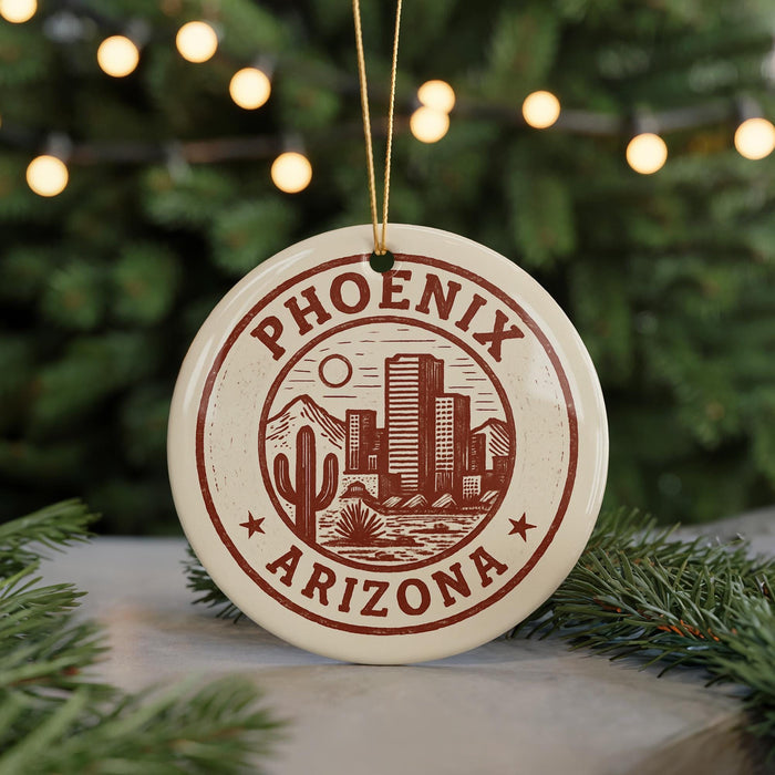 A circular ornament with the text "PHOENIX ARIZONA" and a graphic of a desert city, surrounded by pine branches and twinkling lights.