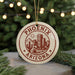 A circular ornament with the text "PHOENIX ARIZONA" and a graphic of a desert city, surrounded by pine branches and twinkling lights.