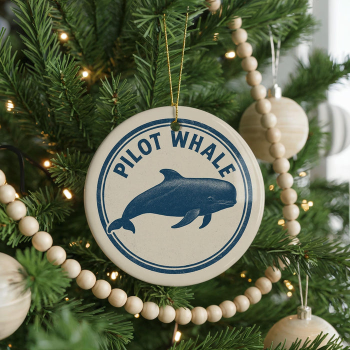 A Christmas tree decorated with ornaments, including a round ornament with a blue whale image and the text "PILOT WHALE" around the edge.