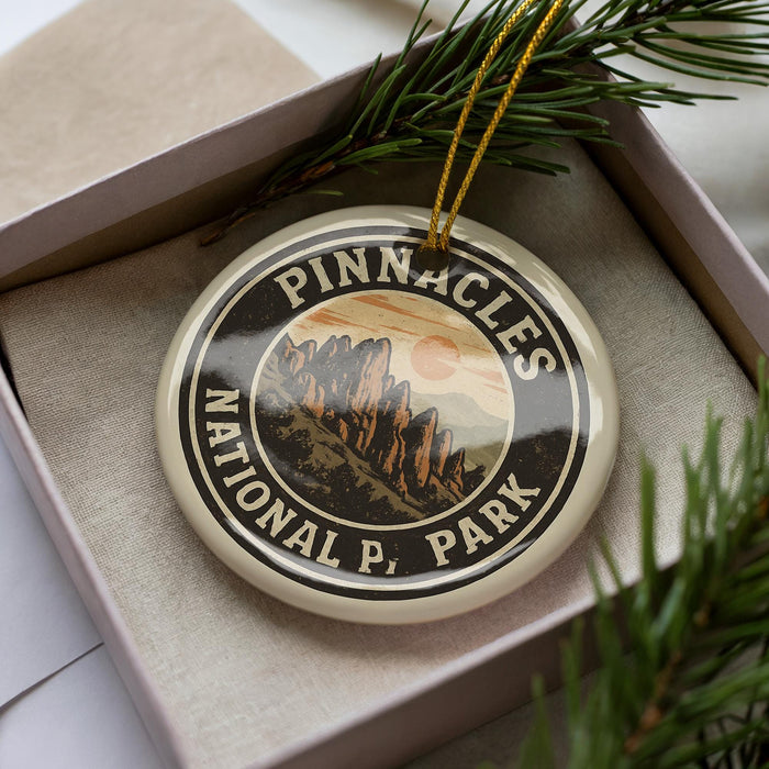 A circular ornament with the text "PINNACLES NATIONAL PARK" printed on it, surrounded by pine branches.