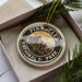 A circular ornament with the text "PINNACLES NATIONAL PARK" printed on it, surrounded by pine branches.