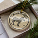 A decorative ornament in a box, featuring a zebra illustration and the text "PLAINZERZEBRA" on a circular design.