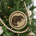 A Christmas tree decorated with ornaments, including a circular ornament featuring a cartoon image of a platypus.