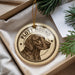 A round ornament with a hound dog image and the text "PLOTT HOUND" is displayed in a box with pine branches.