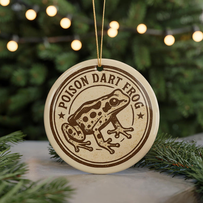 A round ornament featuring a cartoon image of a frog with the text "POISON DART FROG" on it, hanging from a string.
