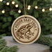 A round ornament featuring a cartoon image of a frog with the text "POISON DART FROG" on it, hanging from a string.