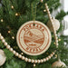A Christmas tree decorated with ornaments, including a circular ornament with the text "POKHARA NEPAUL" and a mountain landscape design.