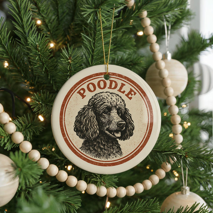 A Christmas tree decorated with ornaments, including a circular ornament with a poodle image and the word "Poodle" written on it.