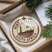A circular ornament with the text "PORT ELIZABETH SOUTH AFRICA" printed on it, hanging from a string.