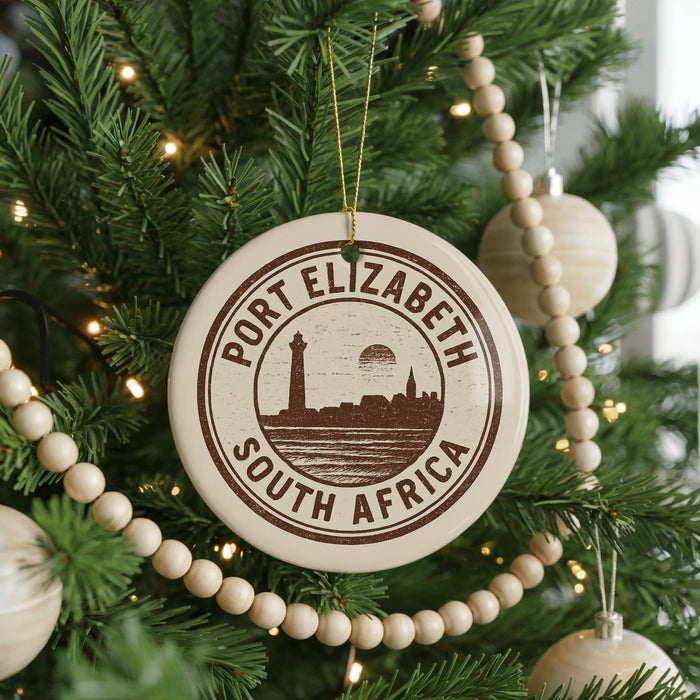 A Christmas tree decorated with ornaments, including a circular ornament with the text "PORT ELIZABETH SOUTH AFRICA" printed on it.