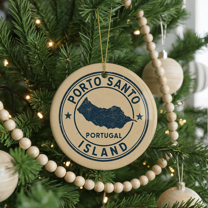 A Christmas tree decorated with ornaments, including a circular ornament with the text "PORTO SANTO PORTUGAL ISLAND" printed on it.