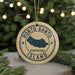 A circular ornament with the text "PORTO SANTO PORTUGAL ISLAND" printed on it, hanging from a string.