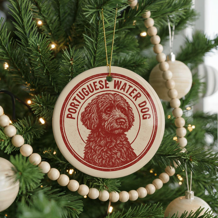 A Christmas tree decorated with ornaments, including a circular ornament with a red and white design featuring a dog's face and the text "Portuguese Water Dog".