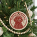 A Christmas tree decorated with ornaments, including a circular ornament with a red and white design featuring a dog's face and the text "Portuguese Water Dog".