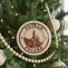 A circular ornament on a Christmas tree, featuring a picture of the Polish city of Poznan, with the text "POLAND" printed on it.