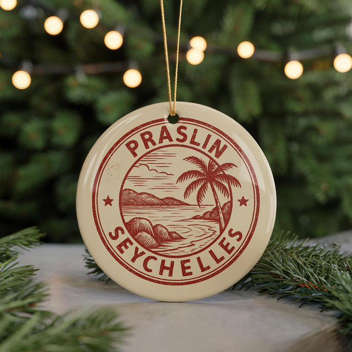 A round ornament with a red and white design hangs in front of a Christmas tree with twinkling lights.