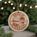 A round ornament with a red and white design hangs in front of a Christmas tree with twinkling lights.
