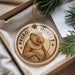 A round ornament featuring a monkey with the text "PROBOSCIIS MONKEY" on it, placed in a box with pine branches.