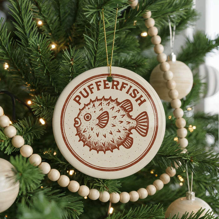 A Christmas tree decorated with ornaments, including a round ornament with a pufferfish design and a beaded ornament.