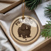 A round ornament with a picture of a poodle dog and the text "PULLI DOG" is displayed in a box, surrounded by pine branches.