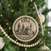 A Christmas tree decorated with ornaments, including a circular ornament with a drawing of a building and the text "PÉCS HUNGARY".