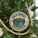 A round ornament on a Christmas tree, featuring a tropical island landscape and the text "RAJA AMPAT INDONESIA".