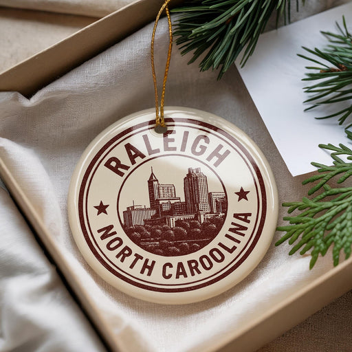 A decorative ornament with the text "RALEIGH NORTH CAROLINA" printed on it, hanging from a string.