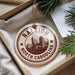A decorative ornament with the text "RALEIGH NORTH CAROLINA" printed on it, hanging from a string.