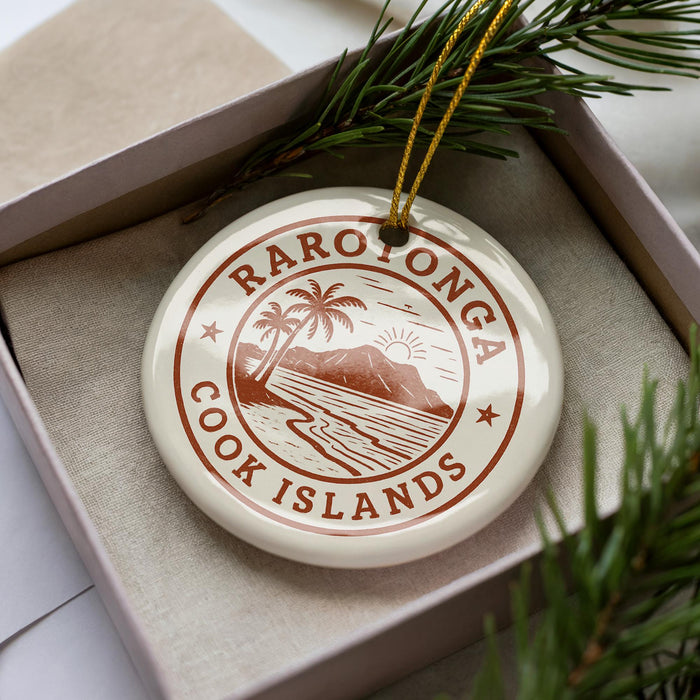 A circular ornament with the text "RAROTONGA COOK ISLANDS" printed on it, surrounded by a decorative element resembling pine branches.