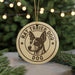 A round ornament with a dog's head and the text "RAT TRIPER DOG" printed on it, hanging from a string.