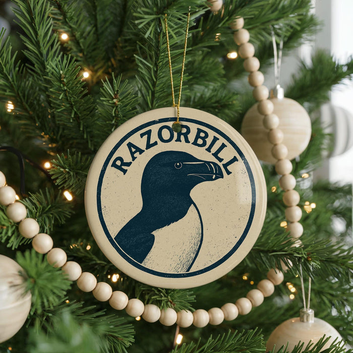 A Christmas tree decorated with ornaments, including a circular ornament with a graphic of a penguin and the text "RAZORBILL".