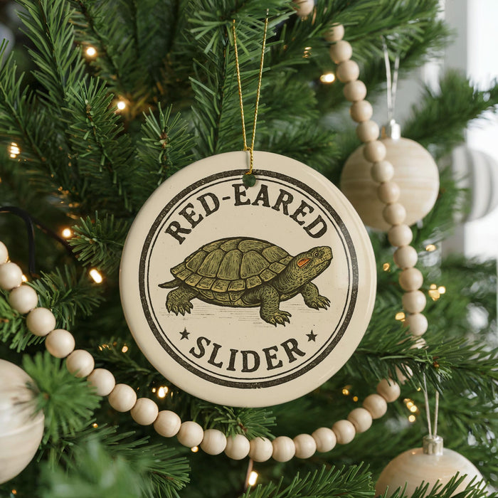 A Christmas tree decorated with ornaments, including a round ornament with a turtle design and the text "RED-EARED SLIDER".