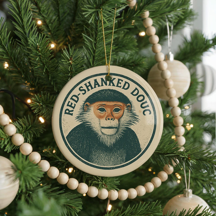 A Christmas tree decorated with ornaments, including a circular ornament featuring a monkey's face and the text "RED SHANKED DOUC".