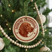 A Christmas tree decorated with ornaments, including a circular ornament with a red and brown image of a redbone coonhound and the text "REDBONE COONHOUND" on it.