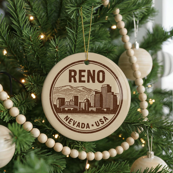 A circular ornament on a Christmas tree, featuring a graphic of a city skyline and the text " Reno, Nevada * USA".
