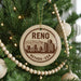 A circular ornament on a Christmas tree, featuring a graphic of a city skyline and the text " Reno, Nevada * USA".